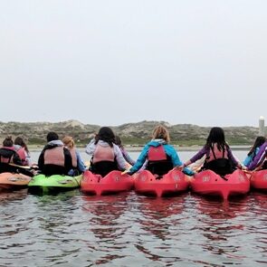 A group of people in kayaks on the water.