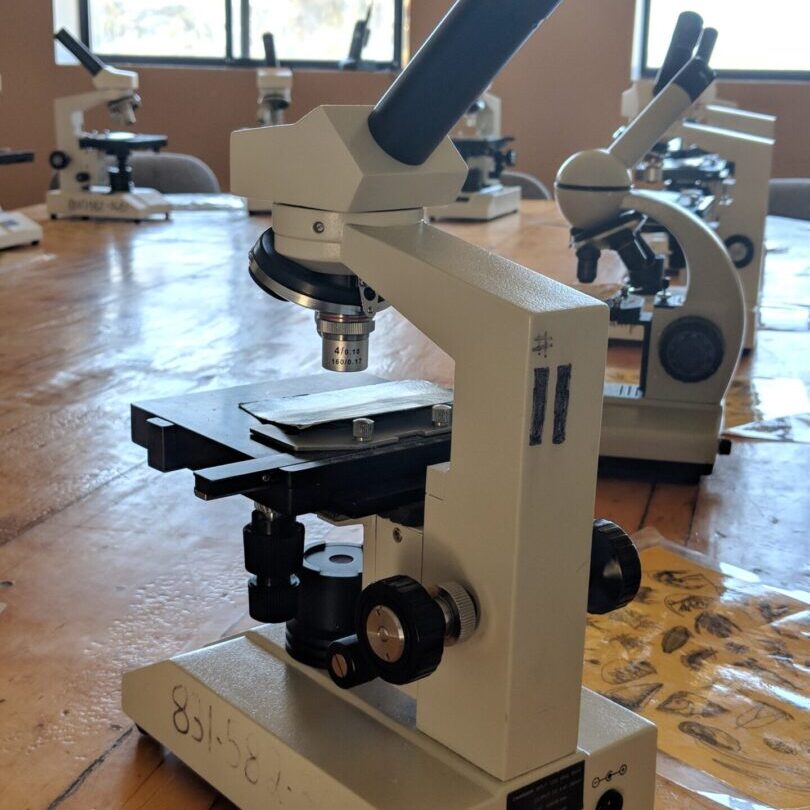 A group of microscopes sitting on top of a wooden floor.